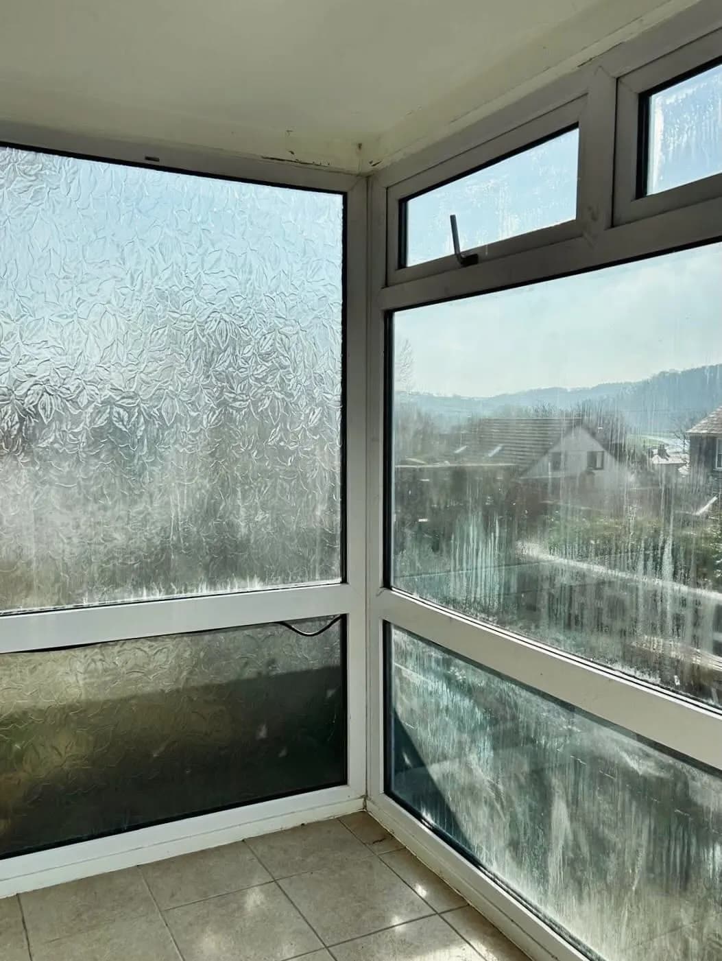 A misted double glazed window with condensation trapped between the panes before replacement
