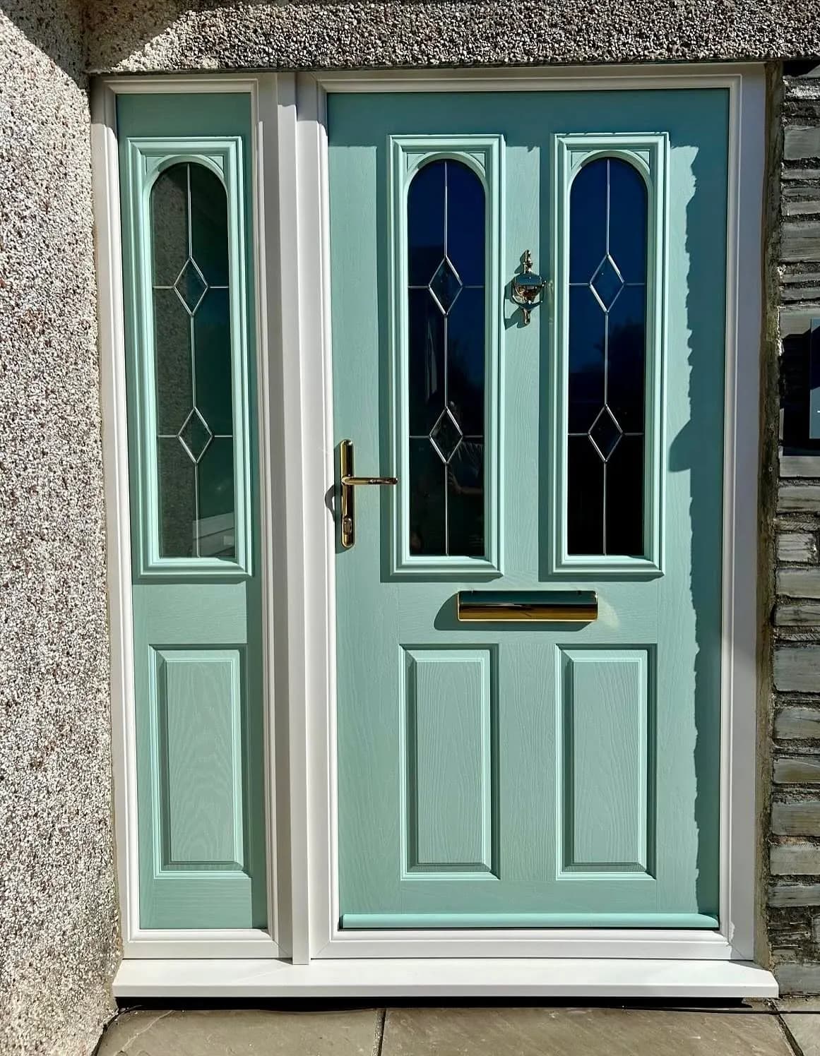 A sage green composite front door with leaded glass panels